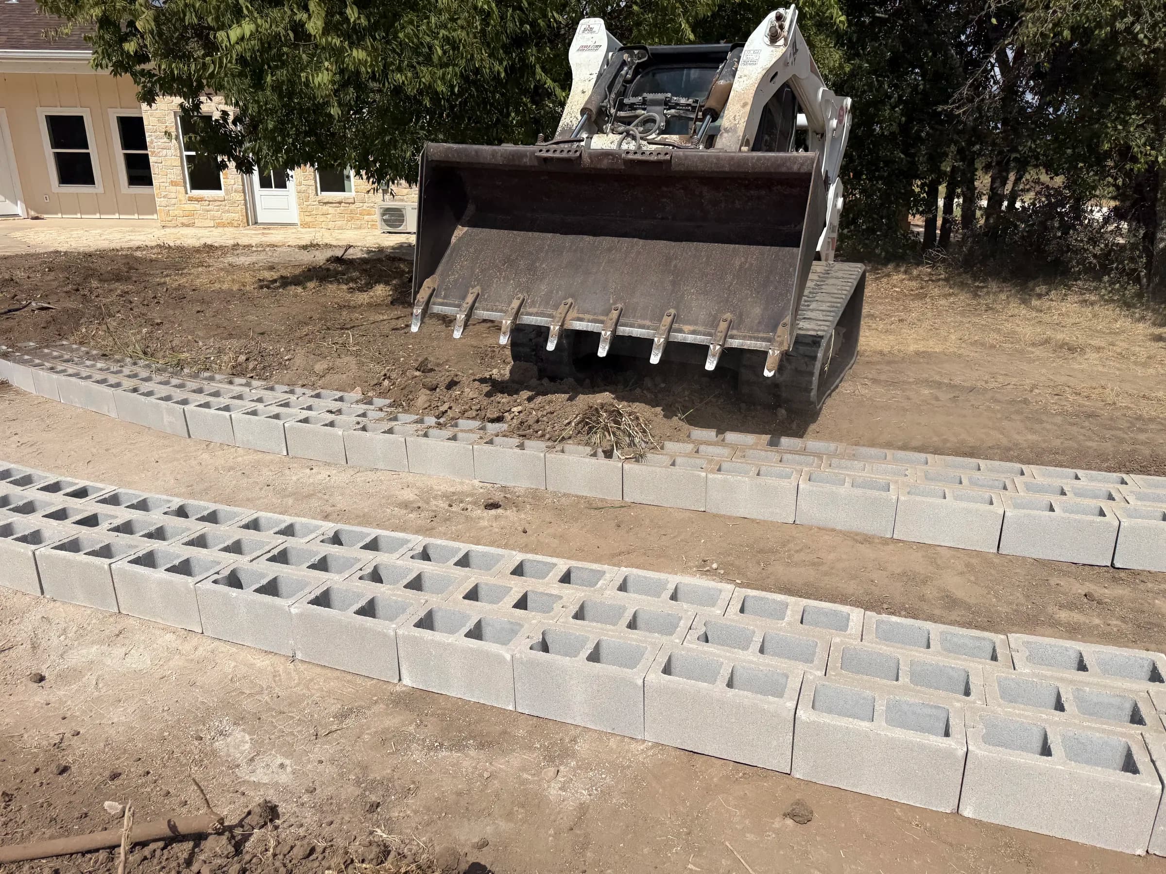 Close view of the concrete blocks and their rectangular grass openings during driveway installation