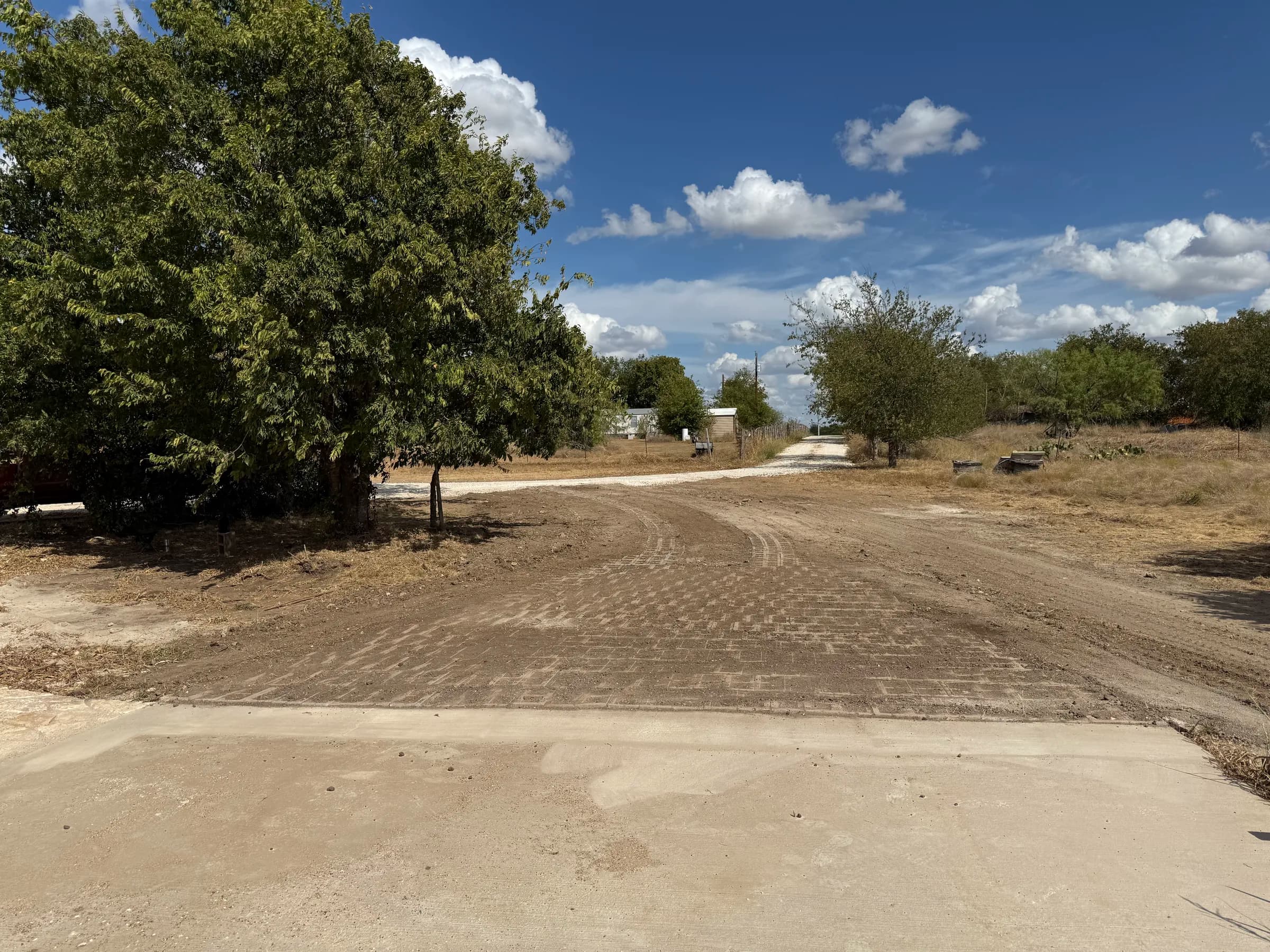 Installed curved driveway viewed from the garage toward the gravel access road