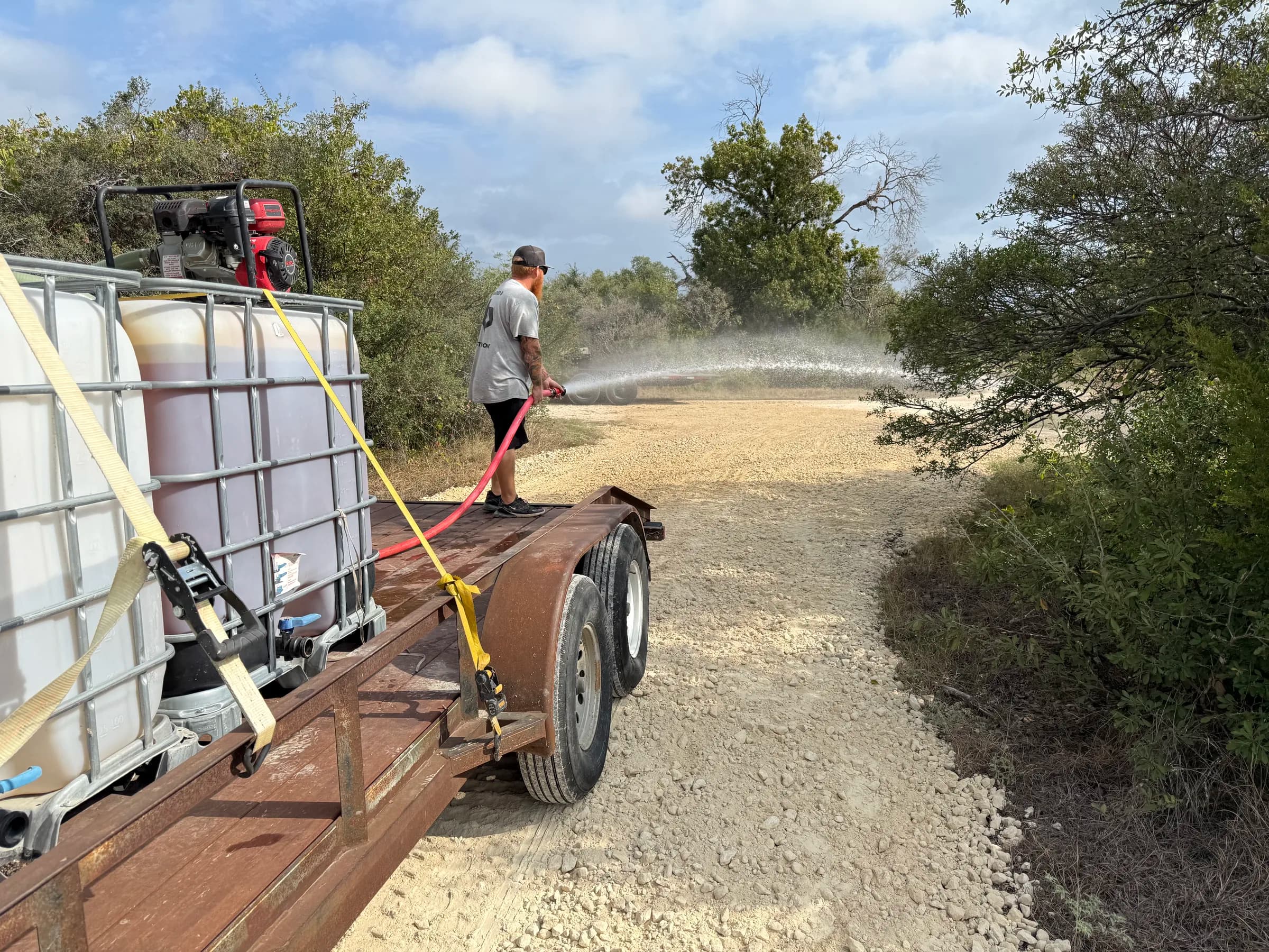 Branded B crew watering aggregate on a Central Texas driveway project