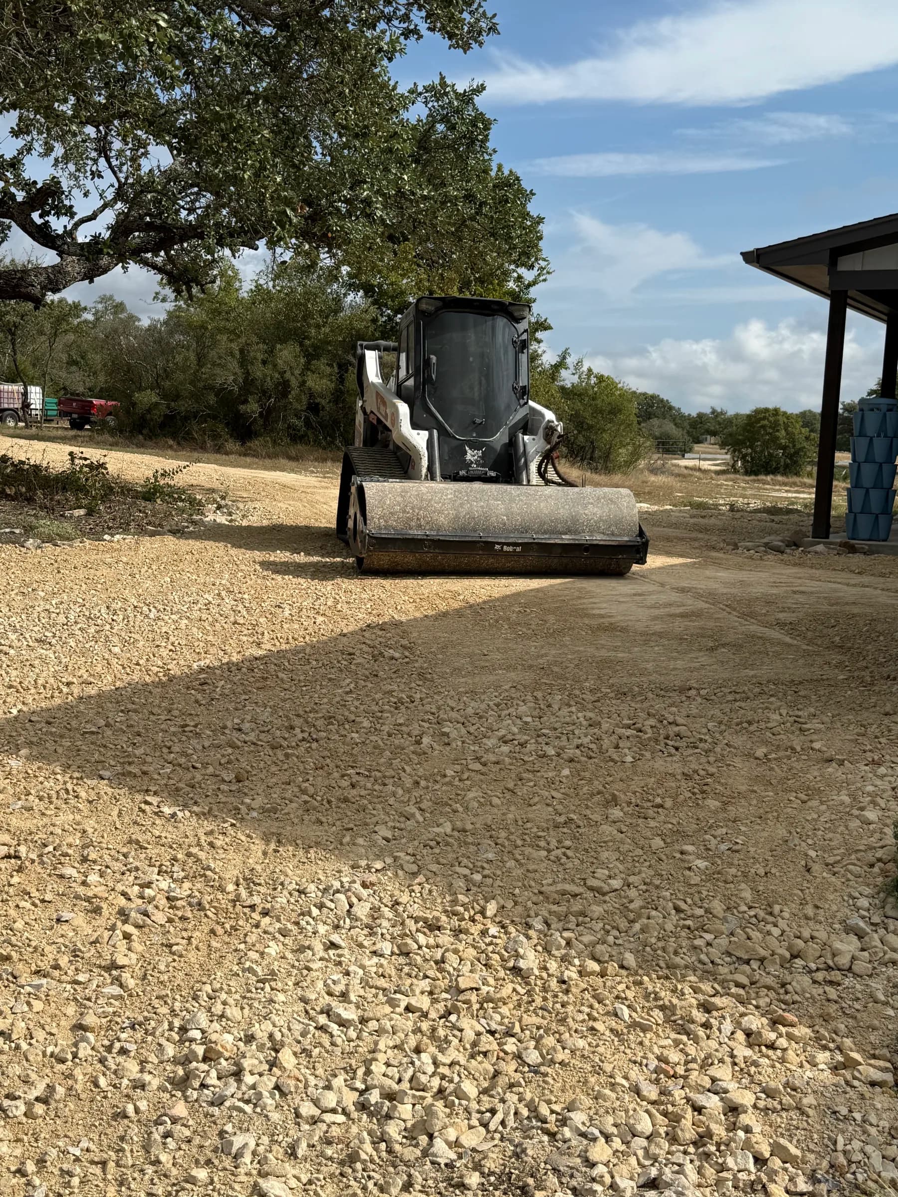 A Bobcat with a roller attachment on the aggregate driveway in Ding Dong