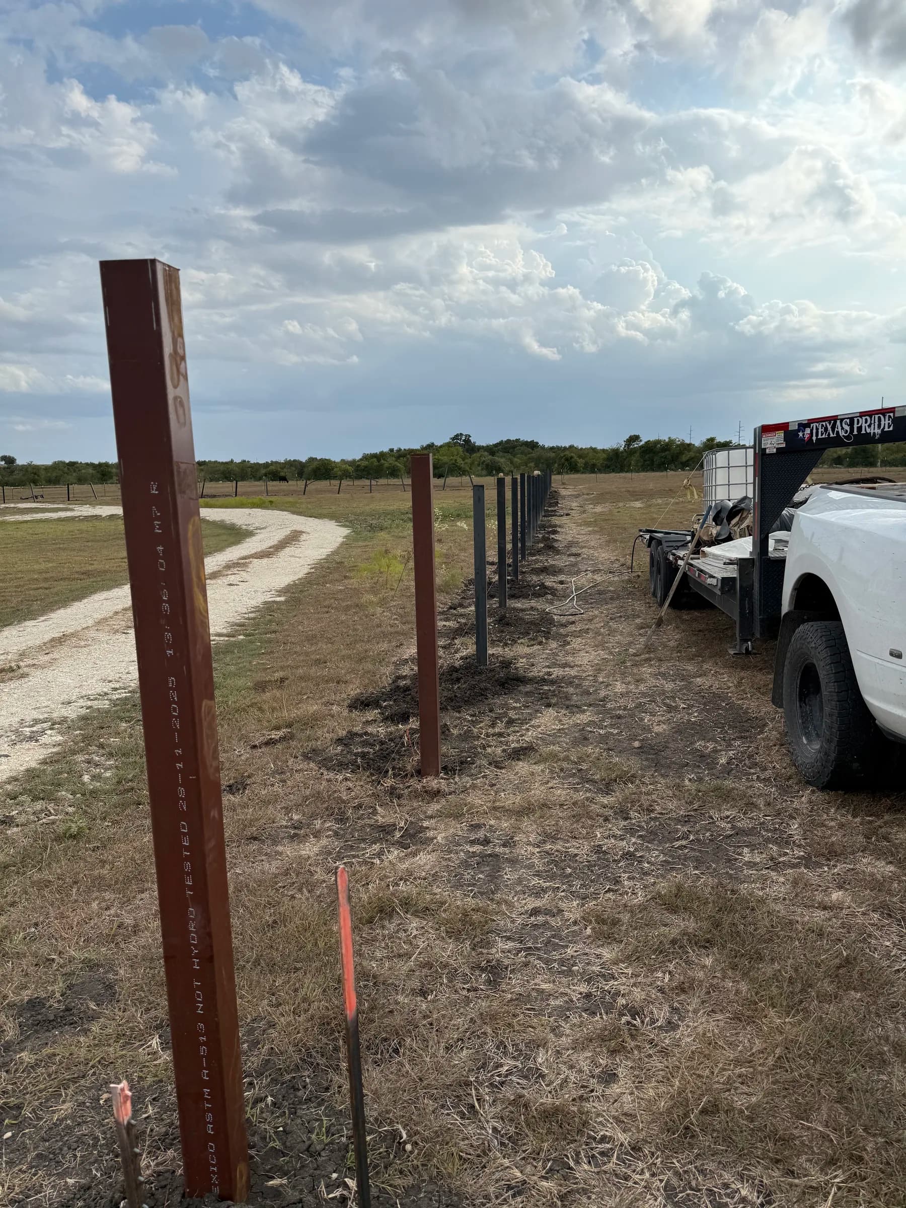 Steel fence posts laid out along a ranch property in Holland