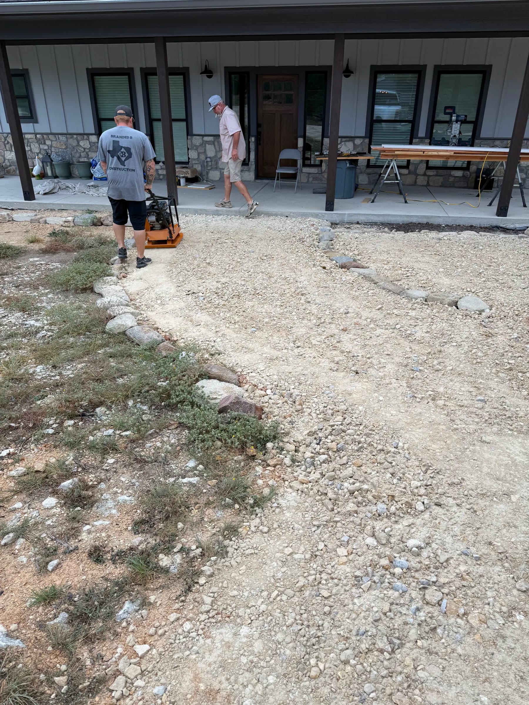 Branded B crew compacting aggregate beside a front porch in Ding Dong