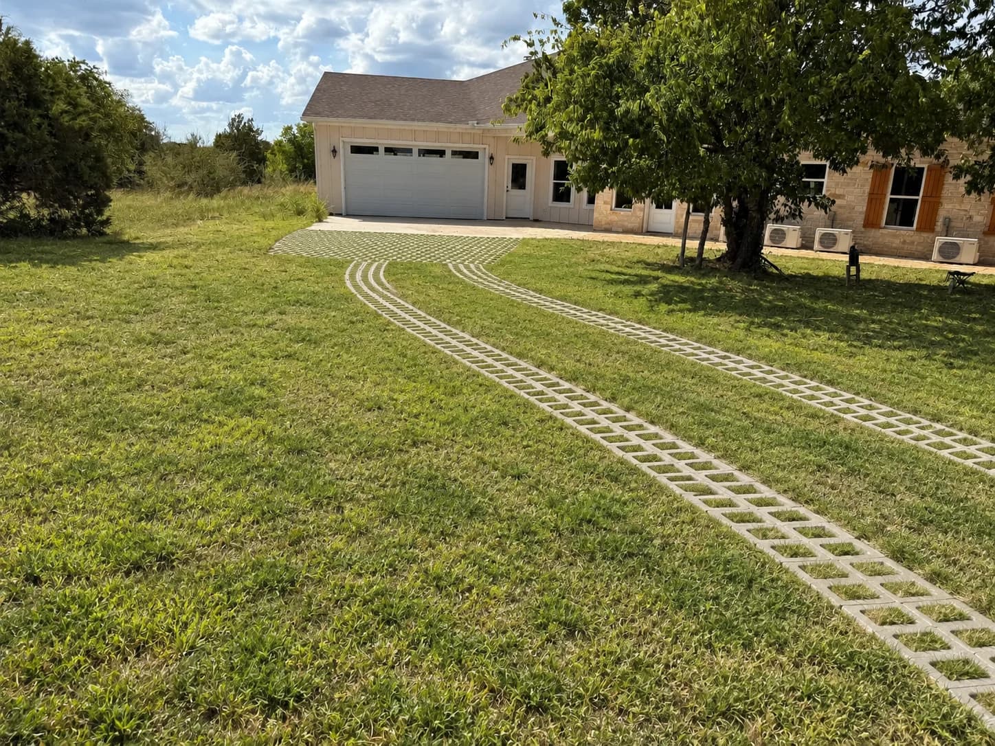 AI visualization of the White Hall driveway with grass in the concrete openings, between the strips, and along the nearby lawn